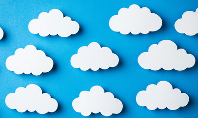 Fototapeta premium White clouds on vibrant blue background create cheerful and playful atmosphere, perfect for evoking feelings of serenity and imagination