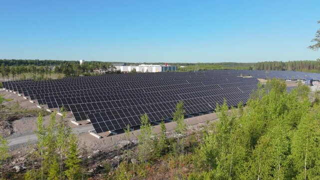 Drone panoramic pullback through trees of bifacial panels at Solar Farm, showcasing renewable energy focus