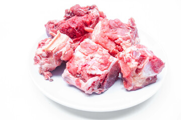 sliced ​​bones and fresh raw beef on a white plate isolated on a white background. fresh spare ribs