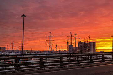 Construction cranes and silhouette of buildings under construction against the colorful dawn sky