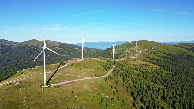 Aerial view of wind farm on a mountain pasture with wind turbines and a vast sky, Deutschlandsberg, Austria.