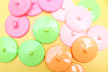 Collection of colorful plastic cup lids isolated on a yellow background