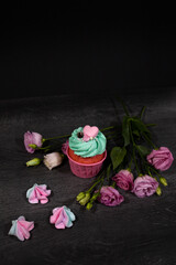 Cupcake with rose. Pink cupcake with mint cream and pink heart. Dark background