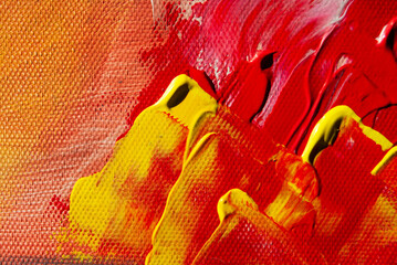 Bold red and yellow acrylic paint layered thickly on canvas, forming a vibrant and textured artistic background.