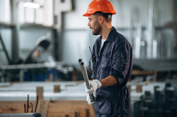 In protective hard hat. Man is working in the modern factory