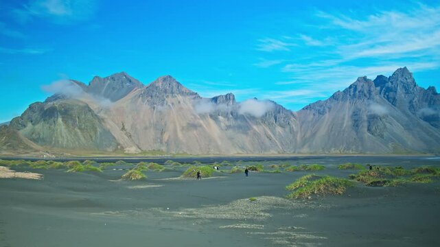 Timelapse of tall scree mountains made of granophyre rocks. Headland with a dramatic mountainscape and black sands.