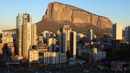 Obraz premium Generative AI, Golden Sunrise Over a Modern Metropolis and Granite Plateau