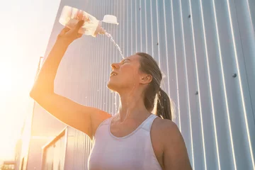  Athletic Woman Drinks water and Splashes Water on Her Face After run © Andrii IURLOV