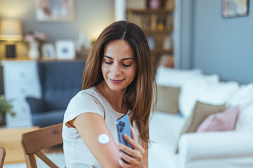 Woman Using Smartphone To Monitor Blood Sugar Levels at Home