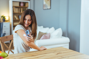 Woman Monitoring Glucose Levels With Smartphone at Home