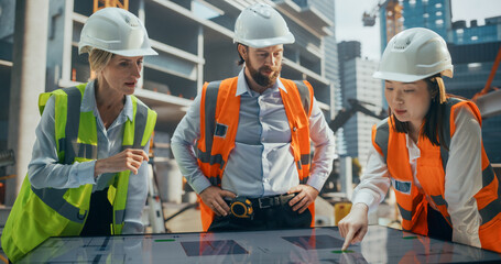 Crew of Construction and Site Managers Having a Meeting at a Site with Skeleton Frame Building with...