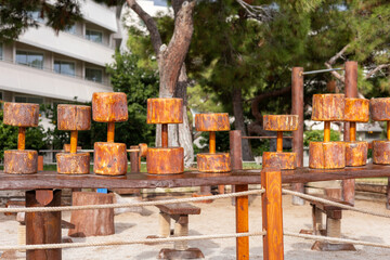 Rusty dumbbells resting on wooden bench in open park during sunny day