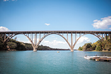 Beautiful arch bridge over clear water in Cuba with lush greenery in the background
