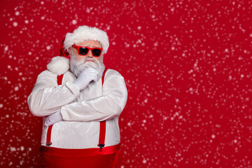 Photo of minded old man ponder december preparation finger chin wear santa hat costume isolated red color background