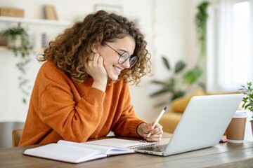 Smiling young woman with curly hair taking notes while studying