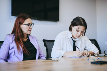 Schoolgirl and teacher have a lesson in the office, private lessons, distance learning