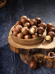 Freshly cracked macadamia nuts in a rustic bowl on a wooden surface, highlighting their natural texture and rich color
