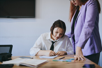 Schoolgirl and teacher have a lesson in the office, private lessons, distance learning