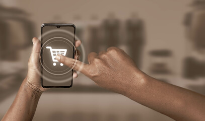 Pushing the shopping cart icon on the smartphone screen. The concept of online shopping