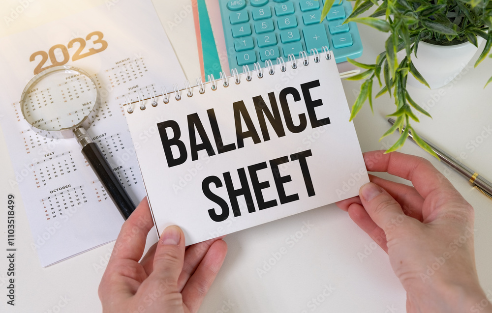 Poster balance sheet text on a notebook with clipboard and calculator on white background