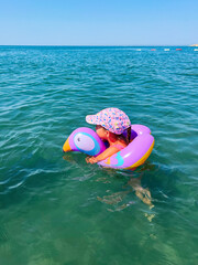 Obraz premium Child enjoying a summer day floating in the ocean
