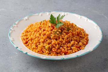 Traditional turkish bulgur pilaf with tomato sause in plate (Turkish name; meyhane pilavi)