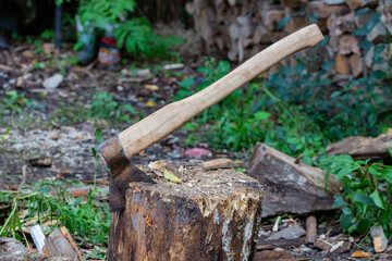 The axe stuck on wooden log. Harvesting firewood for the winter for the fireplace and heating the...