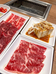 Freshly prepared meat and tofu for grilling.