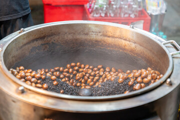 Roasting chestnuts in a rotating drum.