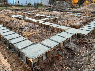 Foundation strips for the construction of a single-family home foundation among trees. Concrete...
