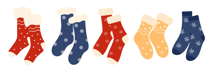 Set of cozy winter Christmas socks, winter shoes with various holiday patterns. Collection of knitted wool and cotton socks with snowflakes isolated on a white background.