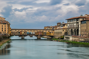 Fototapeta premium Cloudy sky above the medieval Ponte Vecchio bridge crossing the Arno River in the downtown of Florence, Italy