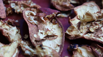 Close-up of dried pomegranate peels scattered on a red surface, highlighting texture and natural detail for eco-friendly, culinary, and sustainable themes
