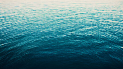 A tranquil overhead view of deep blue ocean water, gently rippling with subtle waves. The calming texture and serene color palette create a peaceful atmosphere.