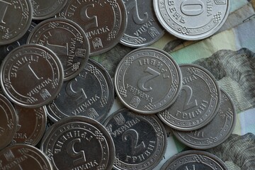 Ukraine money coins lying on mixed hryvnia banknotes, background.