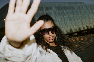 Paparazzi shot of glamorous Middle Eastern female celebrity wearing trendy sunglasses keeping...