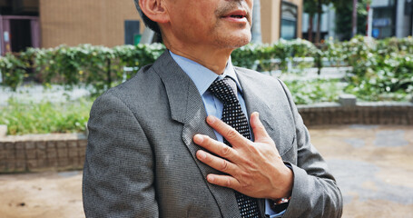 Hand, business man and heart attack, stress and breathing problem or health risk in city in Japan....