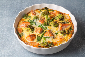 Egg-based frittata, omelette with salmon, broccoli and spinach. Italian dish, crustless quiche with eggs, fish and vegetables. Mediterranean ketogenic healthy diet.