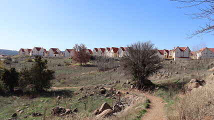 Autumn in Morocco’s Ifrane with Yellowed Maple Leaves, Red-Roofed Houses, Scenic Landscapes, Pedestrian Pathways, and Vibrant Seasonal Foliage in a Serene Countryside Setting  
