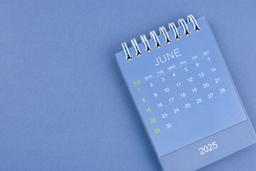 June 2025 calendar on blue background. Desk calendar for planning and organizing.