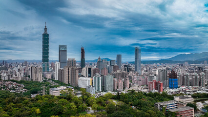 Obraz premium Panoramic view of Taipeis skyline with skyscrapers and lush greenery in front