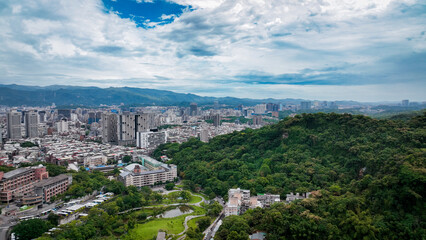 Vibrant landscape of Taipei with urban development and lush green mountains in clear sky