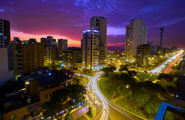 La Costa Verde under the night sky.The city lights dance along the coast, waves softened into mist...
