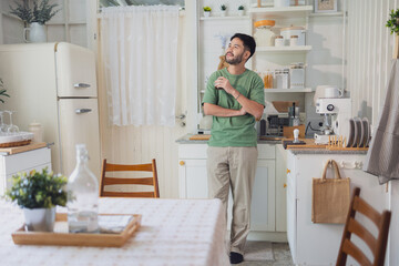 Man Standing Thoughtfully in Bright, Cozy Vintage-Style Kitchen with Natural Light
