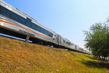Indonesia - August 3, 2024: Indonesian train by on the tracks through the countryside with views of grasslands and blue skies. Kereta Api indonesia (KAI)