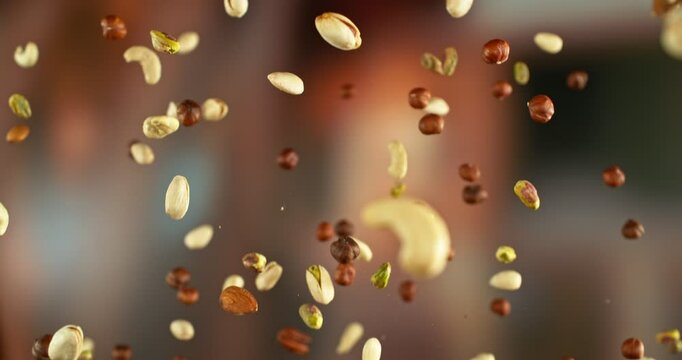 Super Slow Motion of Flying Nuts Mix. Abstract Blur Interior on Background. Filmed on High Speed Cinema Camera , 1000fps. Speed Ramp Effect.