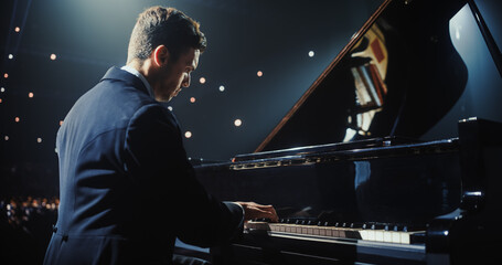 On a Dimly Lit Concert Stage, Male Pianist Delivers an Emotional Improvisation on a Grand Piano....