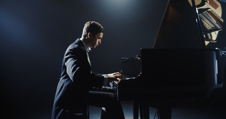 Young Pianist Playing Academic Music, Performing Classical Solo Compositions on a Dark Stage. Grand...