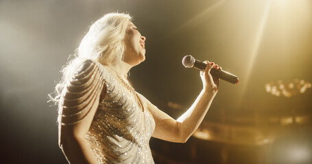 Portrait of a Blonde Musician Using a Microphone to Sing a Powerful Pop Song in a Beautiful Warm...