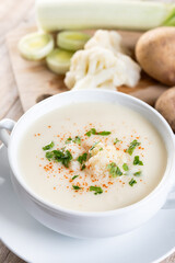Cauliflower soup in bowl on wooden table